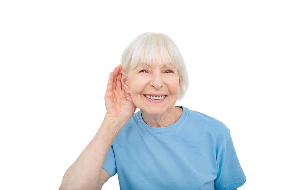 senior in blue shirt holding hand to ear