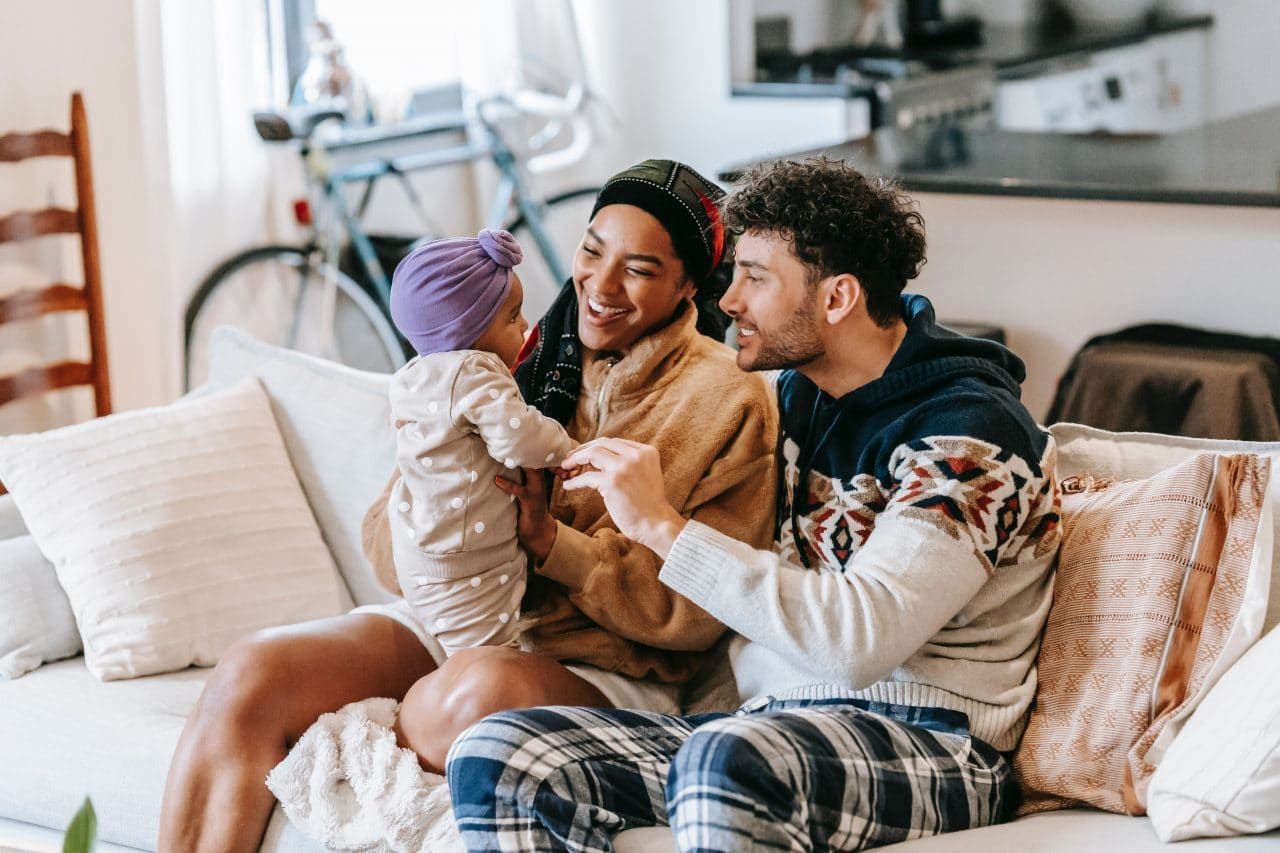 Happy young family talking and playing with their baby.