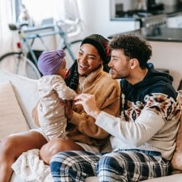 Happy young family talking and playing with their baby.