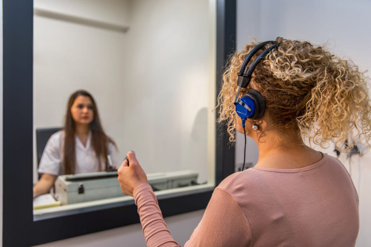 A woman gets an audiology exam.