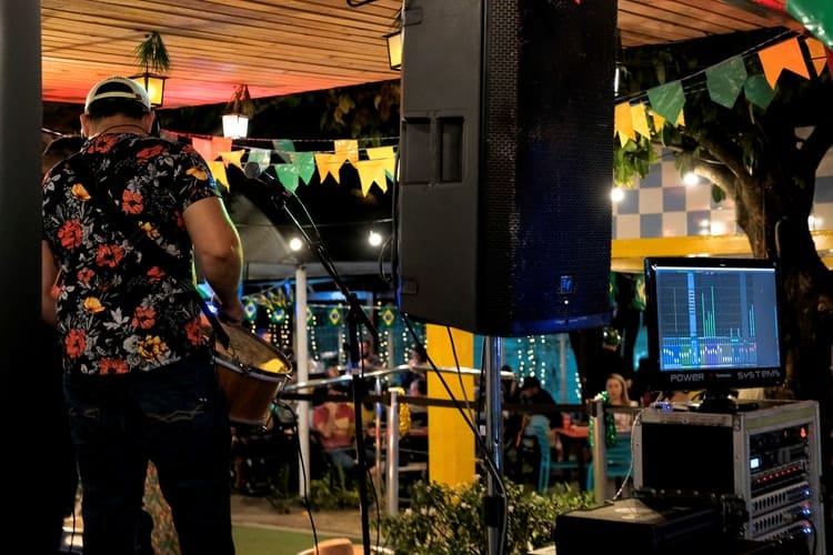 A musician playing guitar at a live music event -- shot from behind