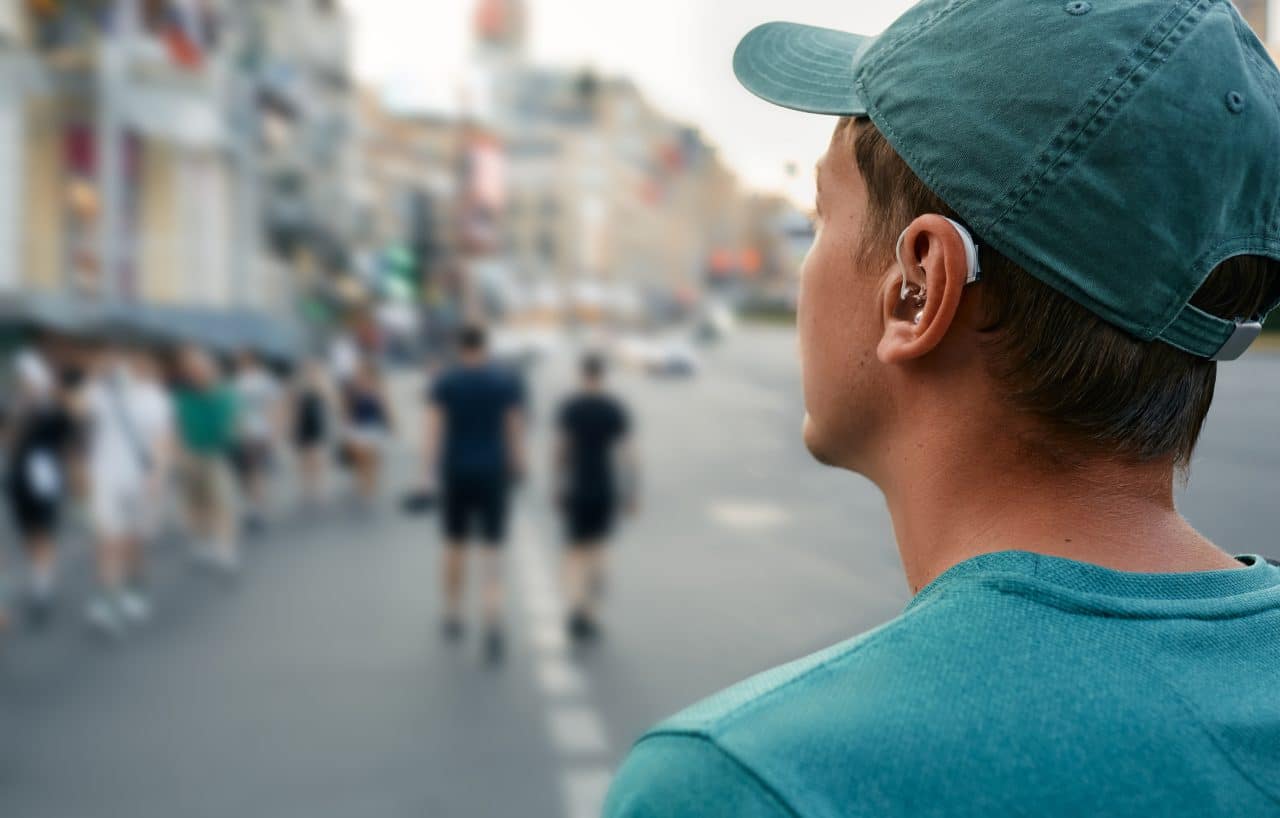 Young man with a hearing aid explores a new city.