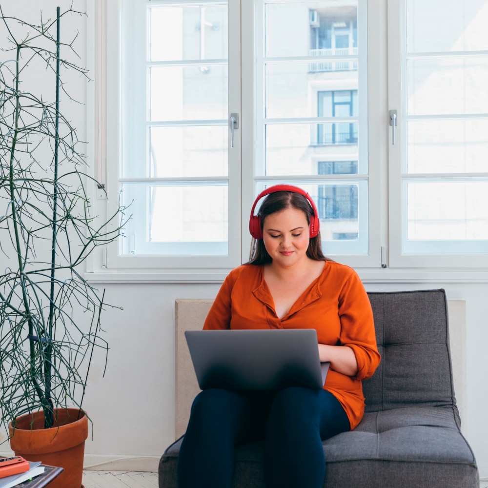 a woman listens to an audiobook while surfing the web in her home