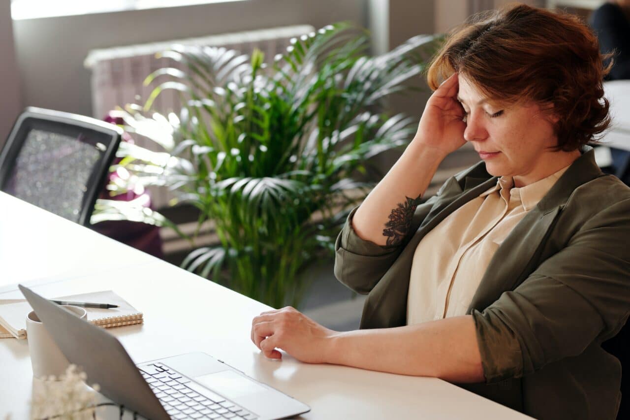 Woman at the office dealing with tinnitus.