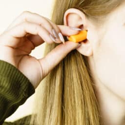 Young girl putting earplugs in
