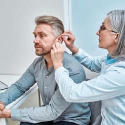 Doctor adjusts hearing aid