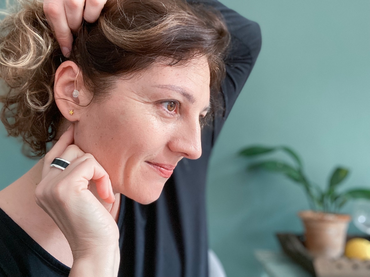 Woman touches her hearing aid