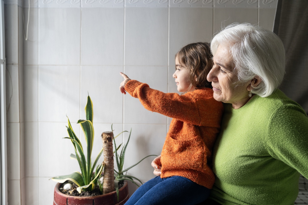 Senior woman with hearing aids playing with her granddaughter.