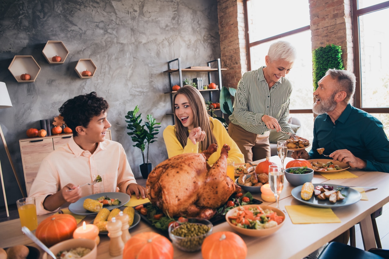 Happy family about to eat a big Thanksgiving dinner.