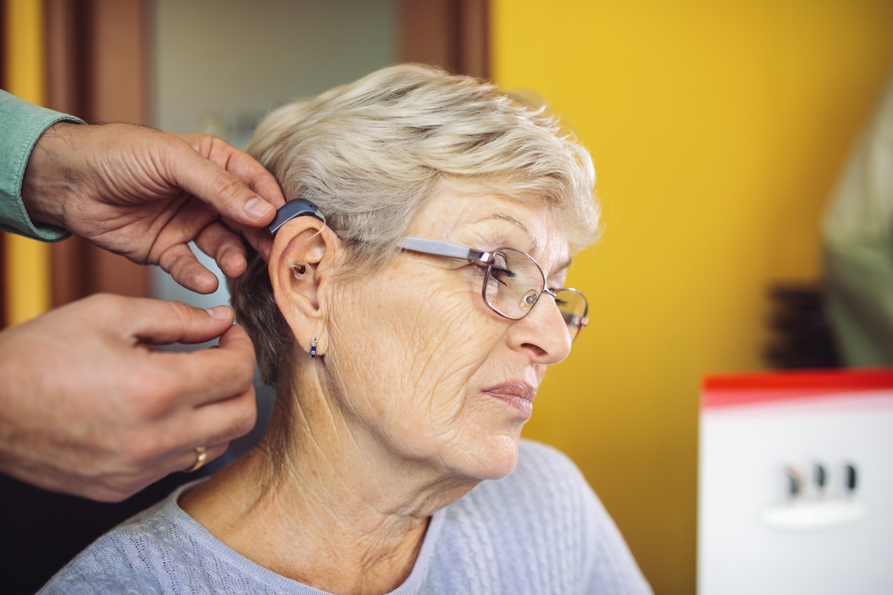 Woman trying on a new hearing aid.