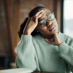 Stressed woman holding her forehead and neck