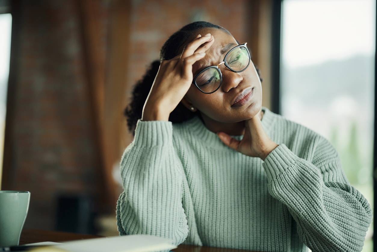 Stressed woman holding her forehead and neck.