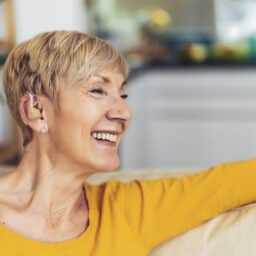 Woman with hearing aid smiles